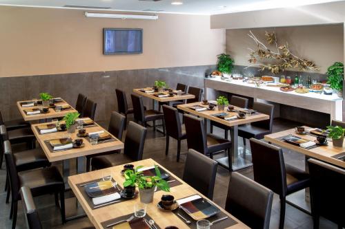 马利亚诺萨比纳萨宾娜公园酒店的用餐室配有木桌和椅子
