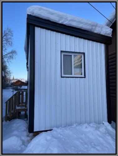 耶洛奈夫Our Cabin Bed & Breakfast的雪中带窗户的小棚