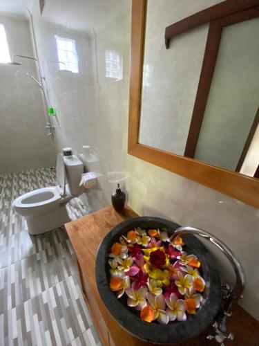 乌布Pondok Serayu的浴室设有水槽,内有一碗鲜花