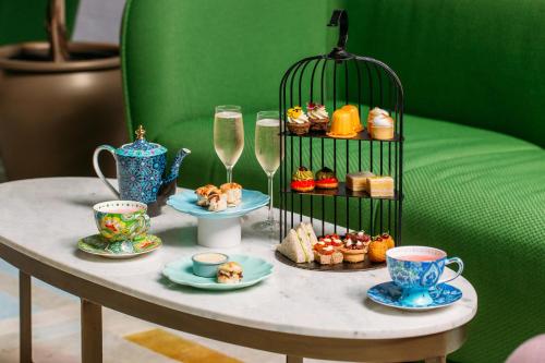 惠灵顿Naumi Hotel Wellington的桌子,上面有杯子和盘子,食物和饮料