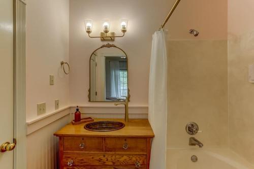 Bonne Terre Inn Crabapple的浴室配有盥洗盆、镜子和浴缸