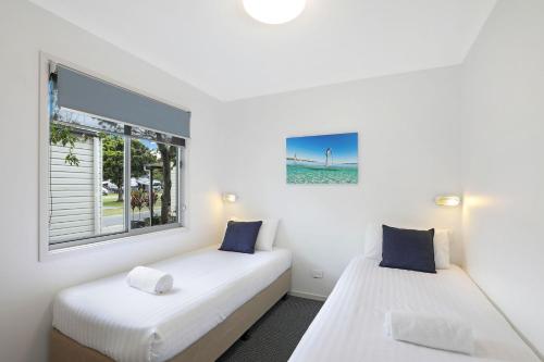 福斯特Reflections Forster Beach - Holiday Park的带窗户的客房内的两张床