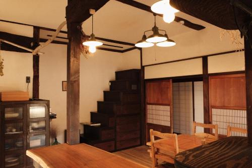 中津川市Guesthouse SHIGI的一间带桌子和楼梯的客厅