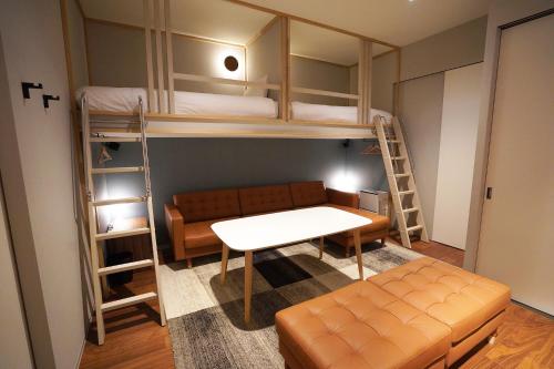 札幌Riverside Hotel Sapporo的客房设有双层床、沙发和桌子。