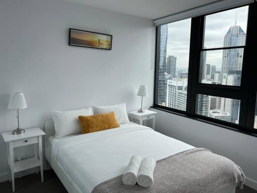 墨尔本Pars apartments - Melbourne Quarter- unique View of city and Yarra的卧室设有白色的床和大窗户