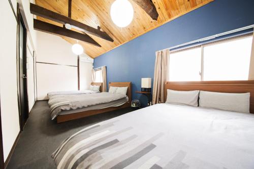 东京ACT one的一间卧室设有两张床和蓝色的墙壁