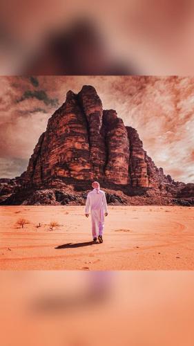 瓦迪拉姆MOHAMMED ZAWAIDAH CAMP的山前在沙地上行走的人