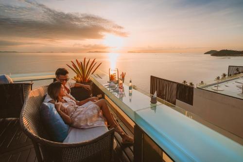 塔林甘海滩InterContinental Koh Samui Resort, an IHG Hotel的坐在游艇甲板上酒吧的一对夫妇