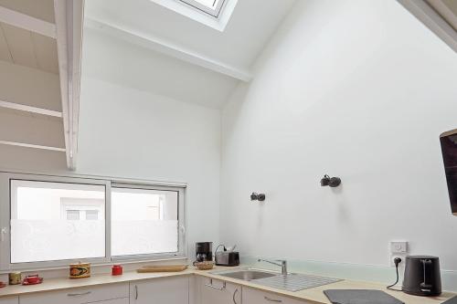波尔尼克La Galerie Pornic - Maison Cedre的白色的厨房设有水槽和窗户