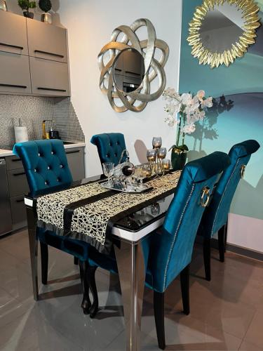 斯维诺乌伊希切Apartament 308的一间带桌子和蓝色椅子的用餐室