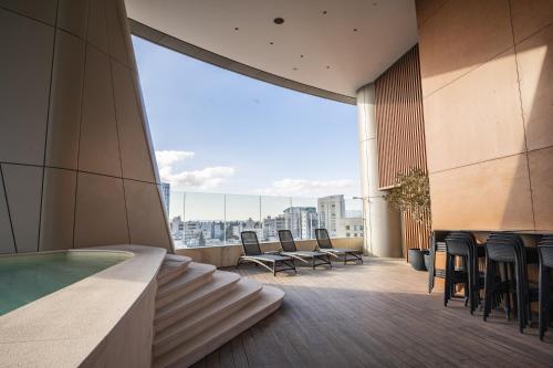 尼科西亚360 Nicosia - Luxury Apartment Panoramic View的大楼内带椅子和游泳池的阳台