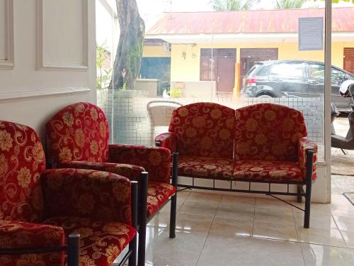明古鲁省Reddoorz @ Kanaka GuestHouse的两把椅子和一张沙发放在储藏室的窗户上