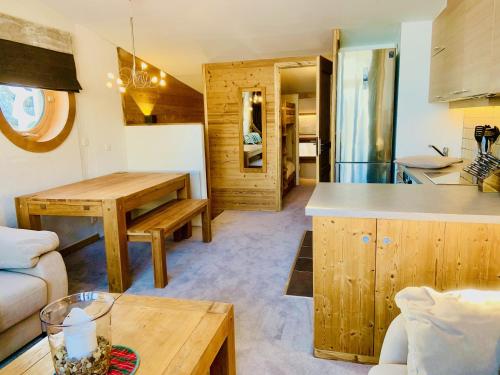 阿沃里亚兹Luxury Chalet with sauna by Avoriaz Chalets的厨房以及带桌子的客厅。