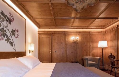 科尔蒂纳丹佩佐法洛里亚山Spa度假酒店的一间卧室设有一张床和木制天花板