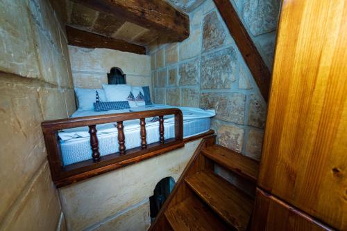 瓦莱塔Valletta Traditional Townhouse的一间小房间,在大楼里配有一张床