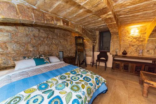 瓦莱塔Valletta Traditional Townhouse的一间卧室设有一张床和石墙