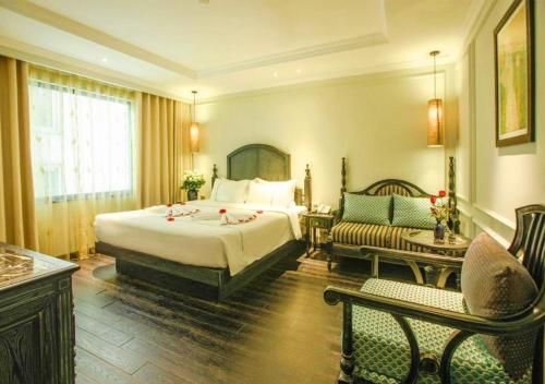 河内Hanoi Emerald Waters Hotel Valley的酒店客房设有一张大床和一张沙发。