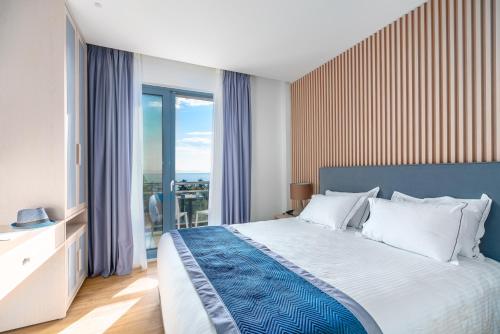 雅典Glyfada Riviera Hotel的一间卧室设有一张床和一个大窗户