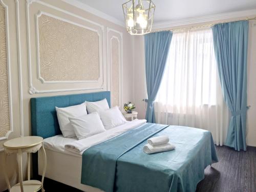 巴甫洛达尔Golden Park Hotel的蓝色和白色的卧室,配有一张带蓝色毯子的床