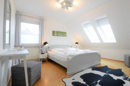 PantowFerienhaus Rügen的卧室配有白色的床和牛地毯。