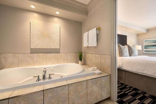 康沃尔康沃尔中心华美达酒店及会议中心的带浴缸和床的浴室