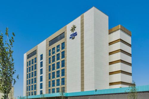 撒马尔罕Hilton Garden Inn Samarkand Sogd的上面有标志的高大的白色建筑
