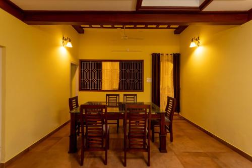 阿勒皮The Mayflower - Heritage Villa的用餐室设有黄色的墙壁和桌椅