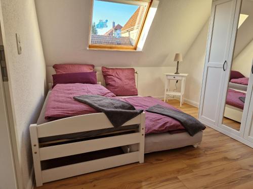 索尔陶Heideherz的一间小卧室,配有一张带紫色床单的床