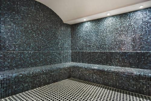 奥尔杜Ramada Plaza by Wyndham Ordu的浴室设有黑色瓷砖墙壁和浴缸。