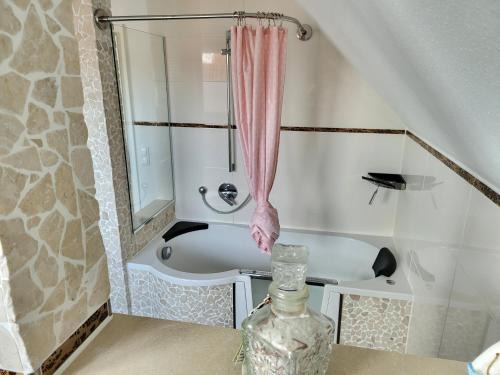 格洛米茨Anker Perla的带浴缸和玻璃花瓶的浴室