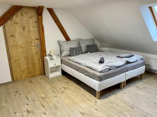 贝希涅Apartmány Bechyně的一间卧室配有一张床,铺有木地板