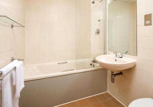 诺里奇诺里奇美居酒店的浴室配有盥洗盆、浴缸和盥洗盆