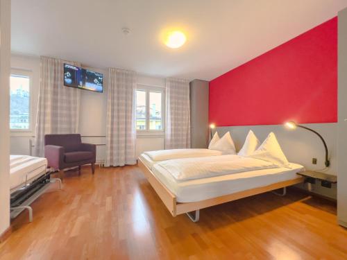 卢塞恩Hotel Rothaus Luzern & Peruvian Culinary Art的一间卧室设有一张大床和红色的墙壁