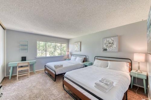 弗雷斯诺Lovely 2 bedroom condo in quiet location的一间卧室设有两张床、一张桌子和一个窗口。