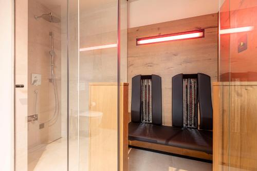 韦斯滕多夫Chalet 149 Westendorf by ALPS RESORTS的浴室内带长凳的玻璃淋浴间
