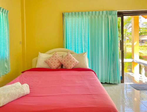 Thungwua laen resort的一间卧室配有红色的床和蓝色窗帘