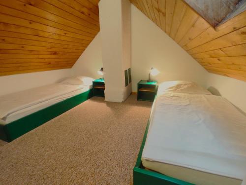 PrevaljeEco tourist farm Mikl的配有木天花板的客房设有两张床。