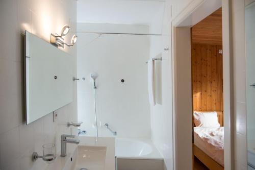 伦策海德Residence for 12 persons Chalet Crestas-Lenzerheide的一间带水槽和镜子的浴室以及一张床