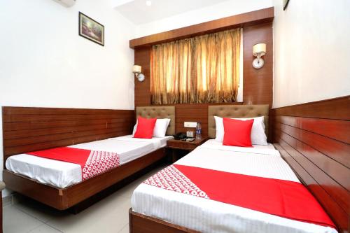 伯蒂亚拉OYO Heritage Corner的两张位于酒店客房的床,配有红色和白色床单