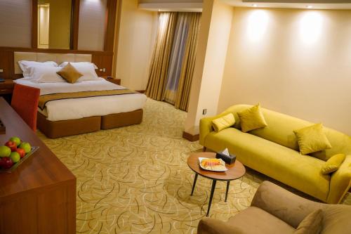 巴格达Shaheen Hotel Baghdad的酒店客房设有一张沙发和一张床