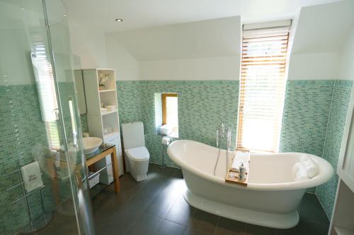 BolneyEast Lodge的带浴缸、卫生间和盥洗盆的浴室