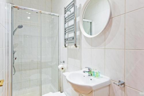 伦敦Calabria 2 - Cosy apartment的一间带水槽、淋浴和镜子的浴室