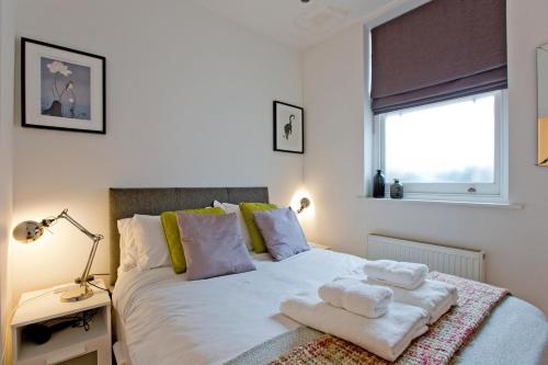 伦敦Calabria 2 - Cosy apartment的一间卧室配有带毛巾的床