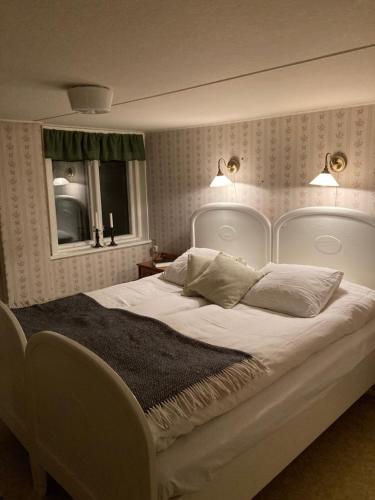 图默利拉Windalens på Österlen的卧室配有一张带两个枕头的大白色床