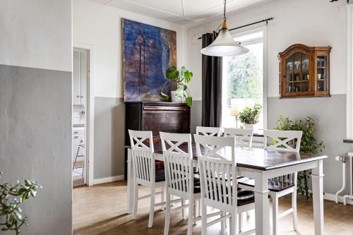 图默利拉Windalens på Österlen的一间配备有白色桌椅的用餐室