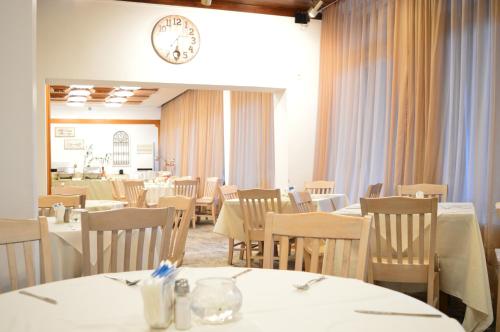 索非亚索非亚里拉酒店的餐厅设有桌椅和墙上的时钟