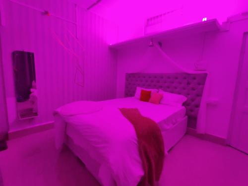 焦尔哈德Gianna Homestay的粉红色的卧室配有床和电视