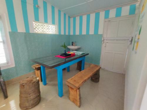 焦尔哈德Gianna Homestay的浴室设有蓝色桌子、水槽和长凳