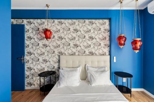 塞图巴尔Wonder Blue的一间卧室配有一张带蓝色墙壁和红色灯的床。