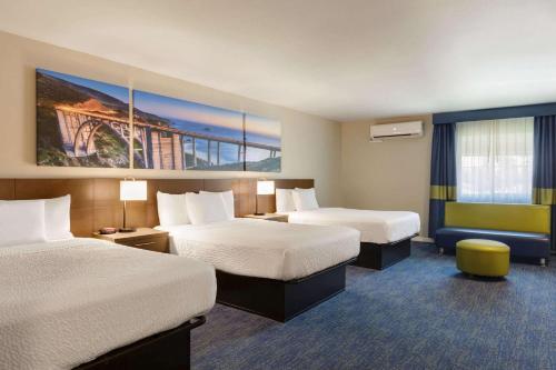 安纳海姆阿娜赫姆公园戴斯酒店 的酒店客房设有两张床,墙上挂有绘画作品